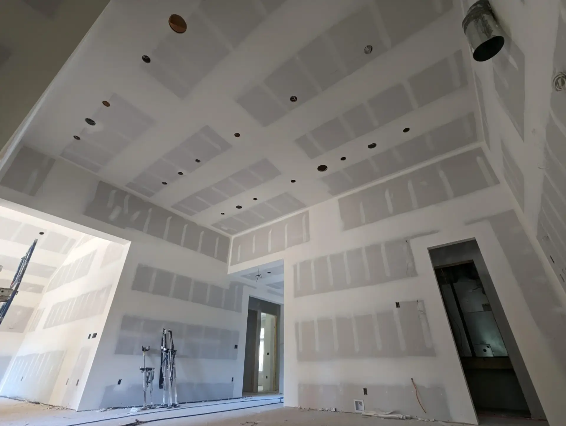 High, multi-ceiling drywall installation in progress