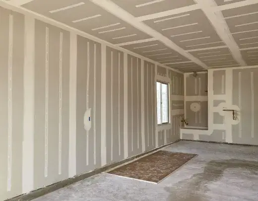 Fully installed and finished drywall room with clean seams and corners